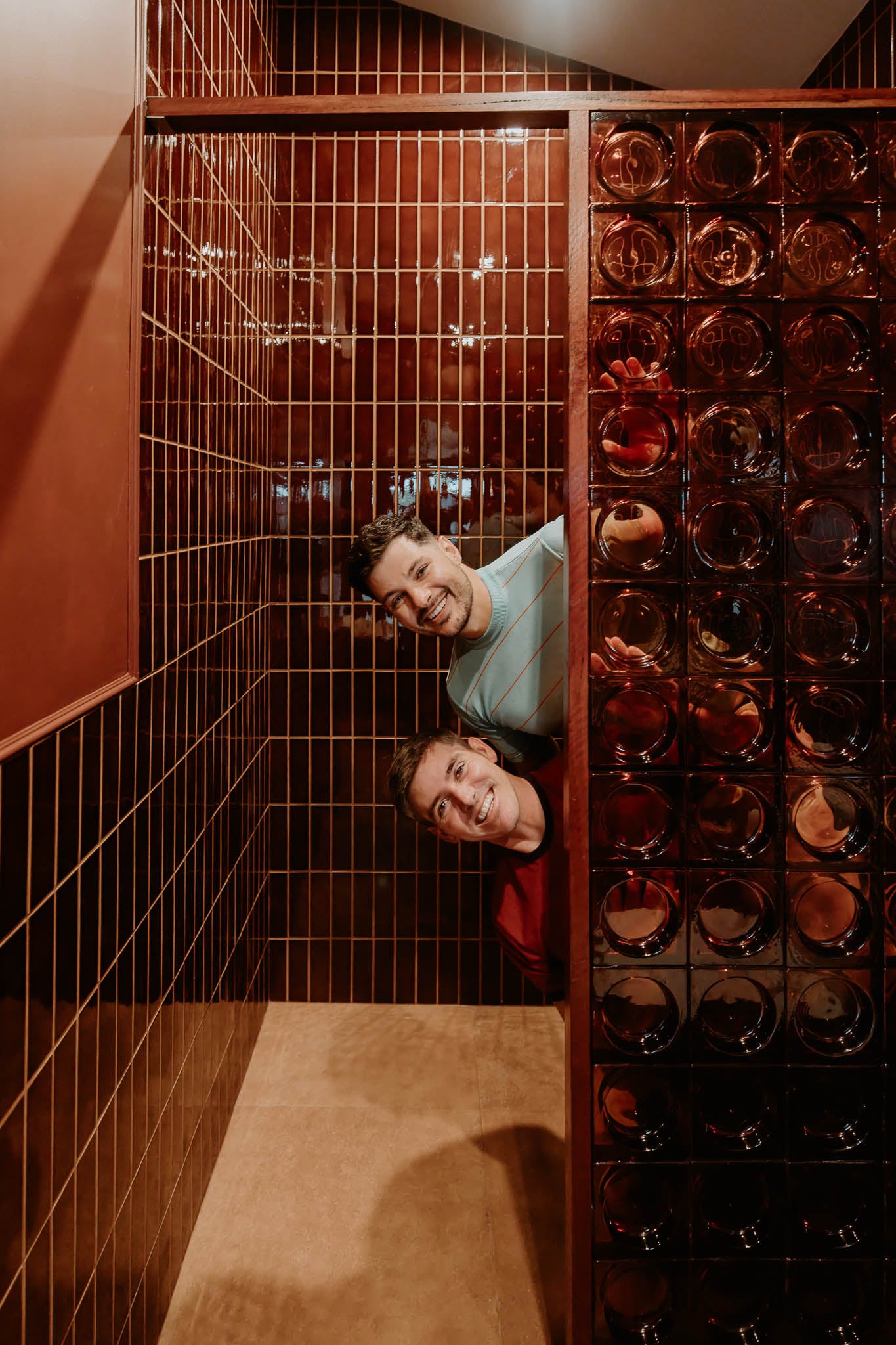 Jordan and Dane peeking around amber glass blocks